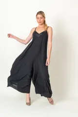 Enterito de viscosa color negro, con diseño holgado y piernas anchas. Presenta escote en V con detalle de satén y breteles finos.