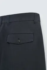 Pantalón de corte regular fit, confeccionado en una mezcla de algodón y lino. Presenta cierre frontal con cremallera y botón, bolsillos laterales y bolsillos traseros con solapa y botón.