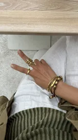 Brazalete rígido abierto de bronce con textura irregular.