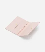 Tarjetero femenino marca Satinato, color rosado, confeccionado en poliuretano texturizado, con logo triangular dorado en la parte inferior.