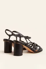 Sandalia de cuero negro con tiras cruzadas en el empeine, diseño en T con tira ajustable al tobillo y taco cuadrado.
