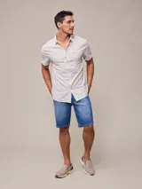 Camisa de manga corta con rayas verticales azules y blancas, confeccionada en algodón.