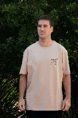 Remera color beige de manga corta con cuello redondo y estampado de dos copas de vino chocando.