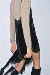 Vestido midi de terciopelo con escote en pico y tirantes finos. Presenta aplicaciones de encaje a tono y un diseño de bajo asimétrico.