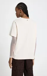 Remera de algodón color crudo con cuello redondo y mangas cortas, que incorpora mangas largas de tul ajustadas por debajo. Presenta un estampado frontal con temática western que incluye cactus y la frase Desert Vibes.