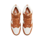 Championes Nike Dunk High de caña alta, con diseño bicolor en blanco y naranja. Presentan una estructura robusta con paneles de tela y cuero sintético, el icónico logo Swoosh en los laterales y suela de goma con tracción.