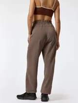 Pantalón jogger color marrón, de corte holgado, con cintura elástica y costuras decorativas frontales.