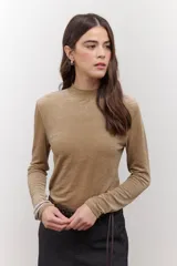 Polera de terciopelo color dorado, con cuello alto y mangas largas.