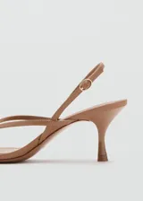 Sandalias de tacón fino y punta cuadrada, color tostado, con diseño de tiras en el empeine estilo thong y tira ajustable en el talón con hebilla metálica.