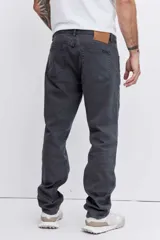 Pantalón de jean corte regular, color gris oscuro, con diseño de cinco bolsillos y cierre frontal con botón y cremallera.
