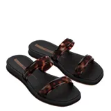 Sandalia tipo slide Ipanema con base negra y dos tiras superiores con estampado de carey en tonos marrones.
