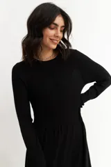 Vestido tejido azul marino de corte a la rodilla, con cuello redondo y mangas largas.