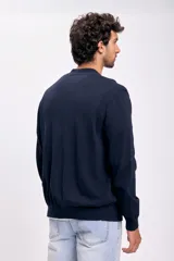 Cardigan de punto en color azul marino, con escote en V, cierre frontal de botones y puños y ruedo acanalados.