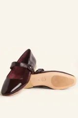 Zapatos tipo Mary Jane con estampado de piel de serpiente, capellada de cuero vacuno, forro y plantilla de cuero vacuno, y suela de cuero. Tienen un taco bajo de 1 cm y una correa con hebilla negra sobre el empeine.