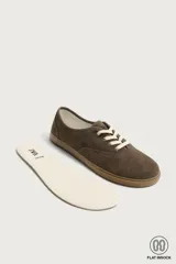 Zapatilla deportiva barefoot fabricada en piel con acabado serraje de color marrón, con cordones en contraste y suela fina de goma.