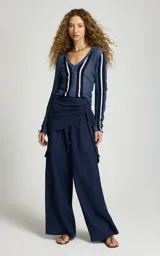 Sweater fino Le Lis Blanc modelo Kris, de tejido calado y transparente color azul con escote en V profundo y rayas verticales en contraste blanca y azul marino en el frente y las mangas.