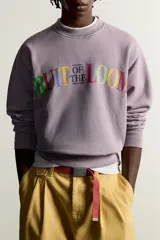 Buzo relaxed fit Fruit of the Loom x Zara color lila con efecto lavado, cuello redondo y manga larga. Estampación frontal de texto multicolor y acabado en rib.