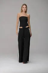 Corset strapless negro con paneles laterales en color blanco, diseño estructurado con costuras visibles y corte asimétrico en la cintura.