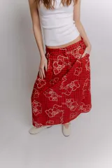 Falda midi de popelina de algodón negra con estampado geométrico de cuadros en tonos blancos, amarillos y rosados, con bolsillos laterales.