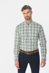 Camisa de manga larga con estampado de cuadros en tonos azules, grises y marrones. Presenta cuello abotonado, bolsillo frontal en el pecho y botones personalizados.