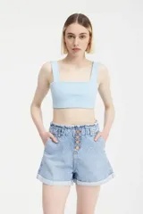Short de jean celeste con cintura elastizada, detalle de botones y estampado de lunares blancos.