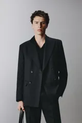 Blazer cruzado regular fit negro, con solapa de pico, bolsillos con solapa en la cadera, bolsillo de vivo en el pecho y cierre frontal con doble botonadura.