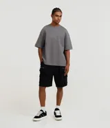 Bermuda cargo para hombre en color negro, confeccionada en mezcla de algodón y poliéster. Cuenta con múltiples bolsillos laterales con cierre de cremallera y diseño urbano.