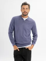 Buzo tejido de punto color azul, con cuello polo y escote en V, de manga larga y puños y ruedo elásticos.