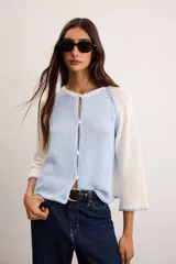 Saco de algodón tejido, color beige con mangas y detalles en blanco, escote en V y cierre frontal de botones.