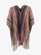 Poncho de tejido de punto con cuello en V y diseño de zigzag multicolor, característico de Missoni. Presenta flecos largos en el ruedo.
