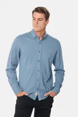 Camisa de manga larga color verde oscuro, con cuello abotonado y logo bordado en el pecho.