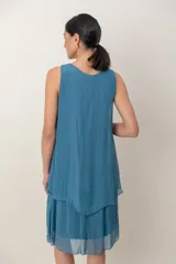 Vestido midi de seda negro con diseño de capas y volados en el bajo, sin mangas y escote redondo fruncido.