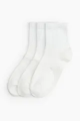 Pack de tres pares de medias blancas de punto fino, con caña corta acanalada y borde superior elástico.