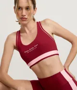 Top deportivo Get Over de espalda nadador, color bordó con detalles en rosado contrastante en los bordes y en la cinta elástica inferior. Presenta lettering frontal y copas incorporadas.