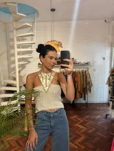 Top tejido en lurex metálico color beige con cuello de cuero con apliques plateados.