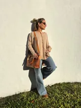 Buzo de tejido de punto color beige, de corte holgado y mangas largas.