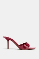 Sandalia de tacón alto estilo mule, con acabado efecto acharolado en color rojo, punta redonda y tacón fino.