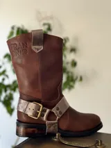 Bota de cuero marrón con estribo desmontable plateado.