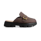 Zueco casual de estilo mule, color marrón, con capellada de cuero sintético y detalle de hebilla metálica dorada. Presenta una suela track de goma negra con plataforma dentada.