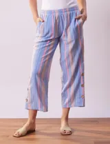 Pantalón de algodón estampado a rayas verticales azules y blancas, marca Erika. Tiene pretina elastizada, bolsillos delanteros, ruedo lateral con tajo y botones decorativos.