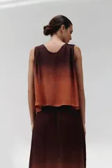 Blusa sin mangas con botones frontales y cuello en V, con diseño degradado de marrón oscuro a naranja.