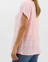 Blusa de corte fluido confeccionada en algodón con tejido texturizado de patrón a cuadros. Presenta mangas cortas caídas, escote redondo y cierre frontal con botones.