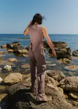 Pantalón color café de lino y rayón, con bolsillos delanteros, elástico en la cintura trasera y lazos en las botamangas para ajustar.