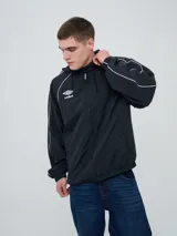 Campera rompevientos Umbro modelo Venti, de color negro con líneas blancas en las mangas y hombros, capucha con cordón de ajuste y cierre frontal completo. Cuenta con el logo de la marca bordado en el pecho.