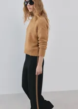 Pantalón de punto negro, de corte ancho y relajado, confeccionado con mezcla de acrílico, poliéster, poliamida y lana.