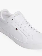 Zapatillas de tenis de corte bajo de la marca Tommy Hilfiger, confeccionadas en piel napa de color blanco. Presentan cordones, punta redonda, suela de goma y detalles distintivos como un pequeño logo esmaltado en el lateral y el nombre de la marca en la lengüeta.