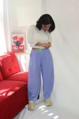 Pantalón de corte holgado y estilo relajado, color lila, con cintura elástica y un aplique decorativo de acrílico en el frente.