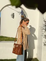 Buzo de tejido de punto color beige, de corte holgado y mangas largas.