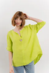 Blusa holgada de lino color verde brillante, con cuello mao abierto y manga corta enrollada. Presenta bordados estilo paisley en tono a tono y un botón de madera en el escote.