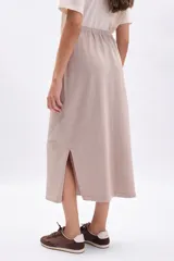 Pollera larga de tejido de punto color beige, con cordón ajustable en la cintura.